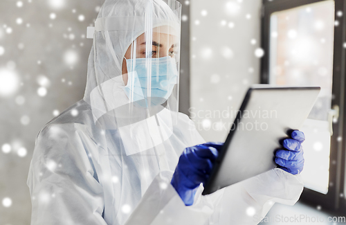 Image of doctor in protective wear with tablet computer