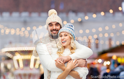 Image of couple in winter hugging over christmas market