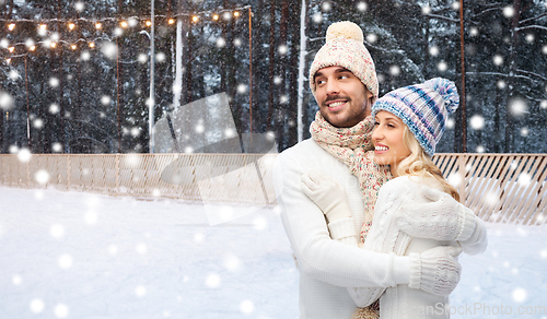 Image of couple hugging over ice skating rink in winter