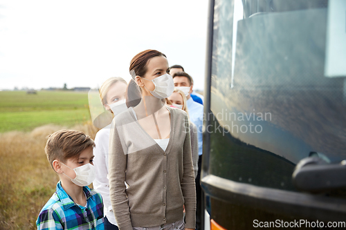 Image of group of passengers in masks boarding travel bus