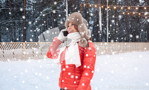 Image of woman calling on smartphone over ice skating rink