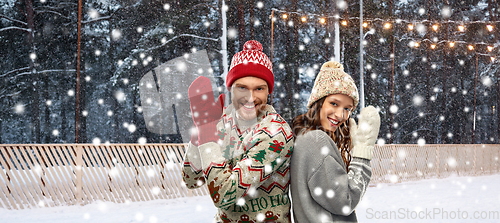 Image of couple in ugly sweaters on christmas ice rink