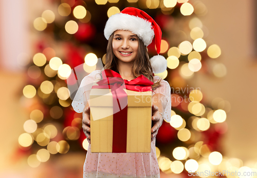 Image of teenage girl in santa hat with christmas gift