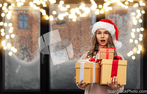 Image of teenage girl in santa hat with christmas gift