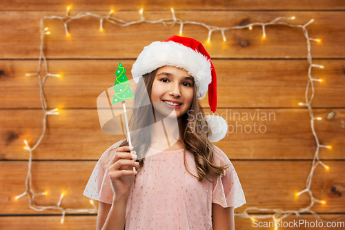 Image of happy teenage girl in santa hat on christmas