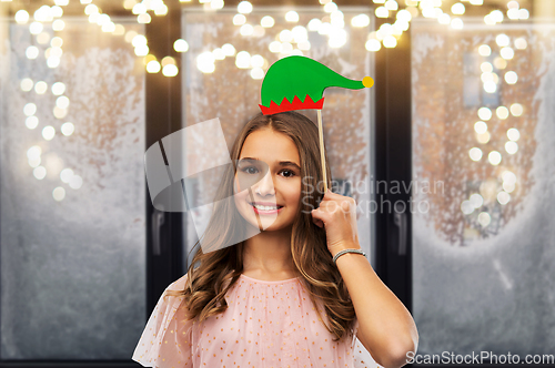 Image of happy teenage girl with santa helper hat accessory