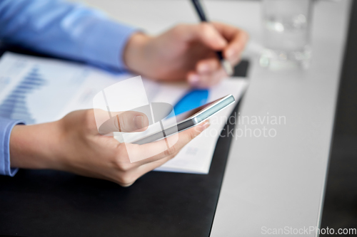 Image of close up of hands with smartphone at office