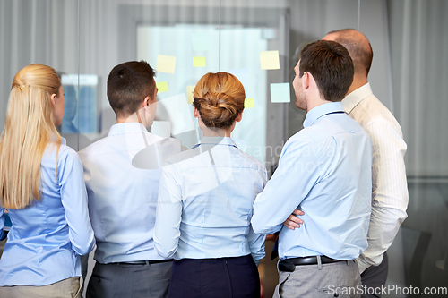 Image of business team with sticky notes on glass at office