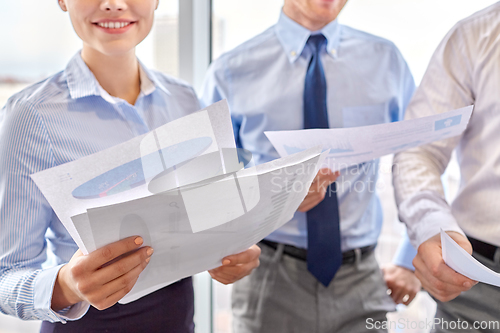 Image of happy business team with papers meeting at office