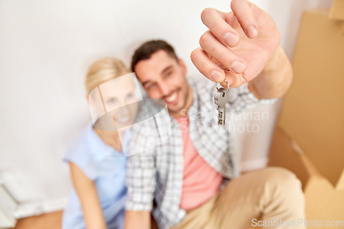 Image of happy couple with key and boxes moving to new home