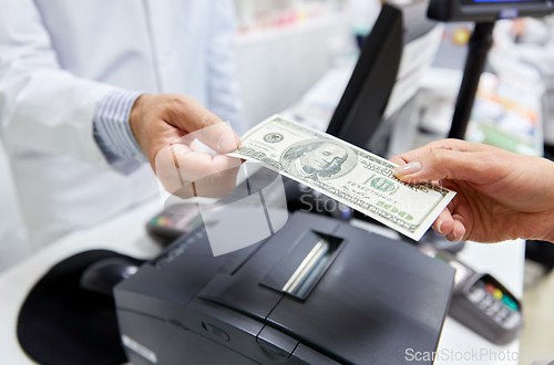 Image of pharmacist taking money from customer at pharmacy