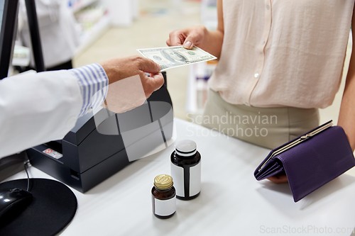 Image of pharmacist taking money from customer at pharmacy