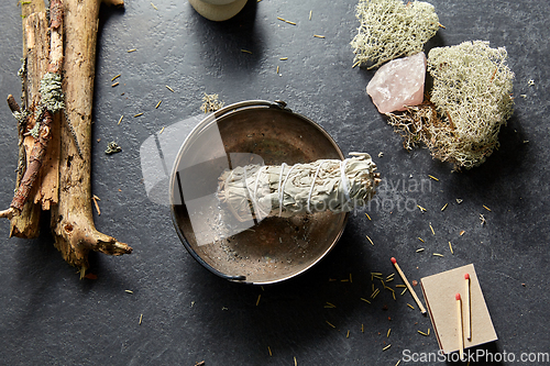 Image of white sage in cup and staff for magic ritual