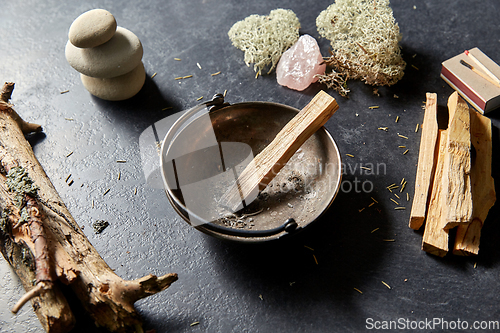 Image of palo santo stick in cup and staff for magic ritual