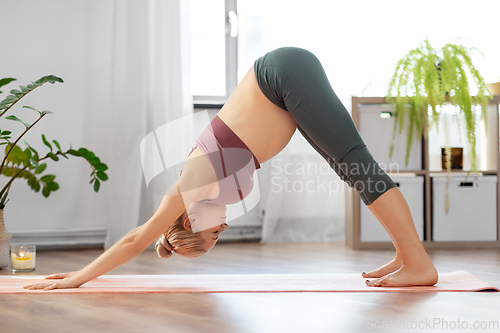 Image of happy pregnant woman doing yoga at home