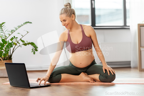 Image of happy pregnant woman doing yoga at home