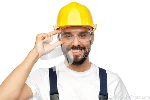 Image of happy male worker or builder in helmet and overall