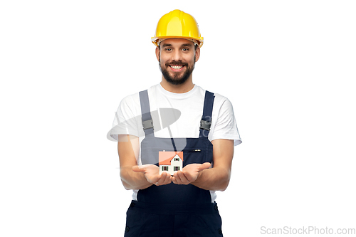 Image of happy male builder holding model of living house