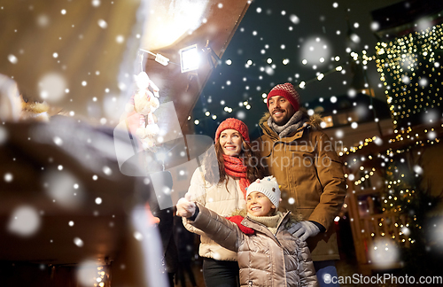 Image of happy family at christmas market in city