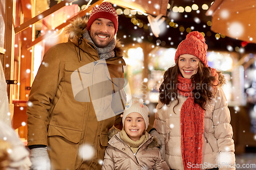 Image of happy family at christmas market in city