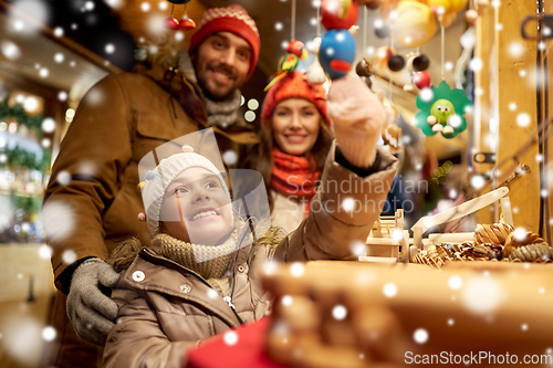 Image of happy family buying souvenirs at christmas market