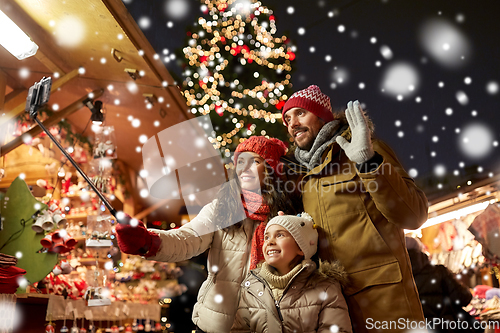 Image of happy family taking selfie at christmas market