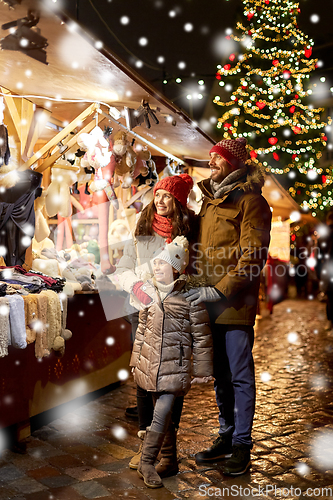 Image of happy family at christmas market in city