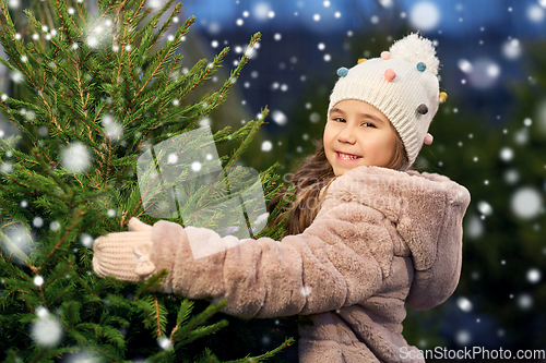 Image of little girl choosing christmas tree at market