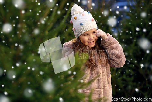 Image of girl calling on smartphone over christmas trees