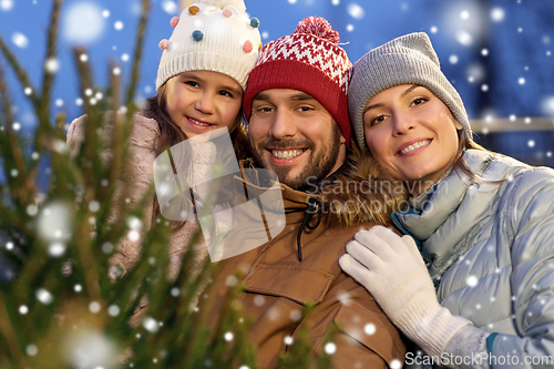 Image of happy family choosing christmas tree at market