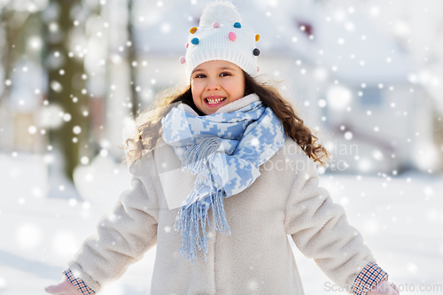 Image of happy little girl in winter clothes outdoors