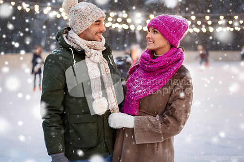 Image of happy couple at outdoor skating rink in winter