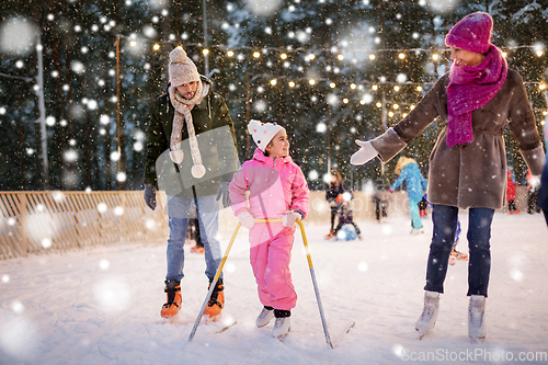 Image of happy family at outdoor skating rink in winter