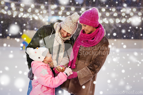 Image of happy family eating pancakes on skating rink