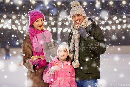 Image of happy family eating pancakes on skating rink