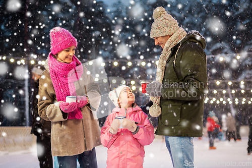 Image of happy family drinking hot tea on skating rink