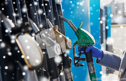 Image of close up of hand in glove with gas nozzle