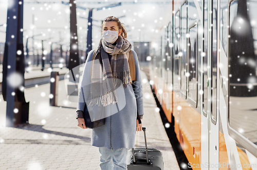Image of woman in protective face mask at railway station