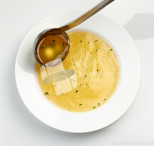 Image of chicken broth pouring into soup plate