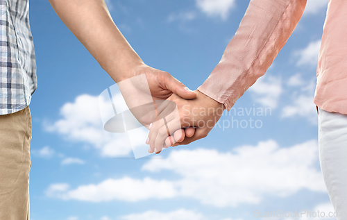 Image of close up of happy couple holding hands at home