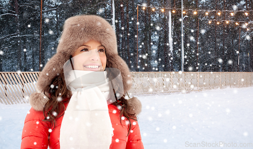 Image of happy woman in winter hat over ice skating rink