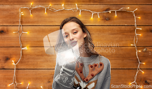 Image of woman in ugly christmas sweater with magical dust