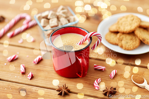 Image of cup of eggnog with candy cane, cookies and sugar