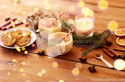 Image of glasses of eggnog, oatmeal cookies and fir branch