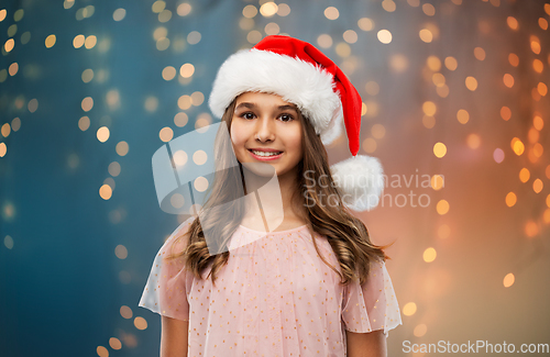 Image of happy teenage girl in santa hat on christmas