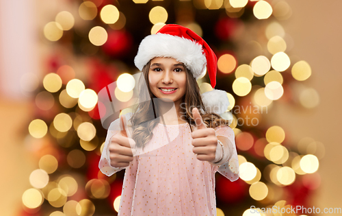 Image of happy teenage girl showing thumbs up on christmas