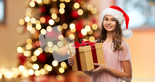 Image of teenage girl in santa hat with christmas gift