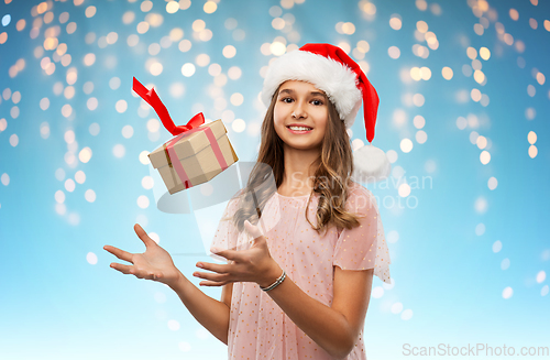 Image of teenage girl in santa hat with christmas gift