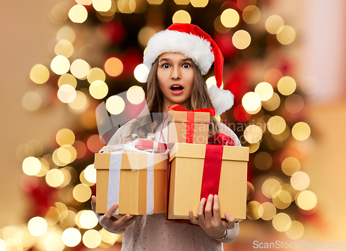 Image of teenage girl in santa hat with christmas gift