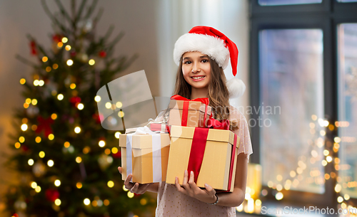 Image of teenage girl in santa hat with christmas gift